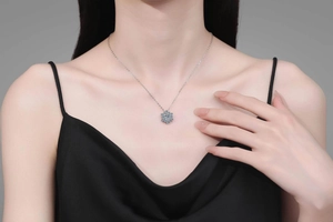 Detail of S925 sterling silver snowflake necklace with 1 carat moissanite on model