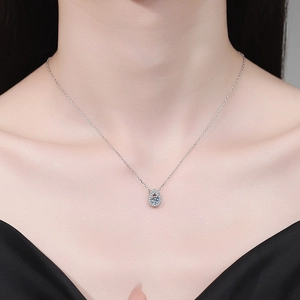 Élégant collier pendentif goutte en argent avec pierre centrale ronde porté par un mannequin