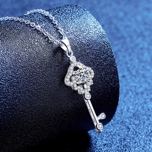 Silver key pendant necklace featuring a sparkling round center moissanite stone