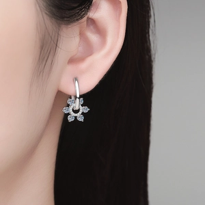 S925 silver flower hoop earrings with blue and white moissanite crystals on a model