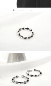 Detail of vintage S925 silver beaded ring with textured horizontal grooves and knot design