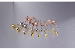 Detailed view of sterling silver ball stud earrings in gold, silver, and rose gold finishes