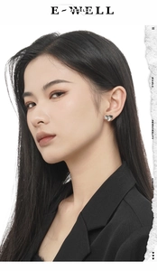 Close-up of minimalist S925 sterling silver heart earrings worn by a model in silver finish