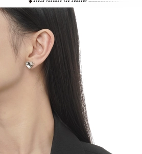 Minimalist S925 sterling silver heart stud earrings worn by a model in close-up view
