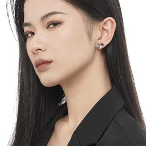 S925 sterling silver heart studs with liquid metal texture on female model's ear