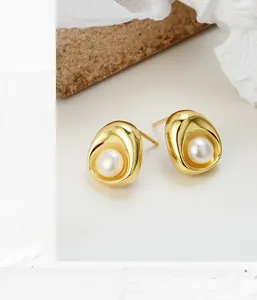 Macro shot of S925 silver oval stud earring with freshwater pearl in golden finish