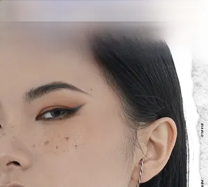 Detailed close-up of a silver twisted line ear cuff earring on model ear in studio light