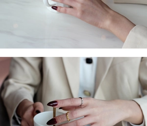 Nahaufnahme minimalistischer Gold- und Silberringe an einer Hand auf Marmor