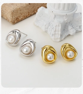 Close-up of S925 sterling silver and gold pearl earrings with geometric concave metal design