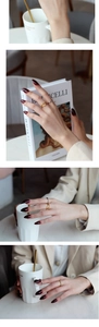 Nahaufnahme von gewellten Gold- und schmalen Silberringen im minimalistischen Layering-Look