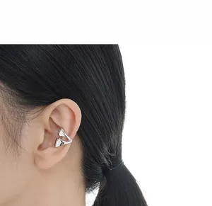 Close-up of minimalist silver geometric double-layer ear cuff on a female model