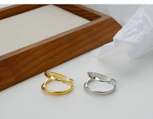 Detail of gold and silver S925 Mobius rings showing double twisted design and metal texture