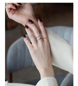 Close-up of minimalist layered S925 silver Mobius ring and gold band on a hand