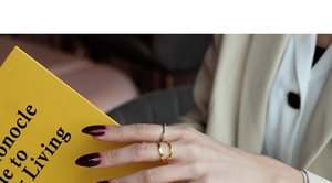 Close-up of gold and silver S925 sterling silver Mobius rings worn on a model's hand