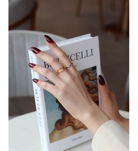 Detail of layered S925 silver irregular wave ring and sleek gold band set on hand