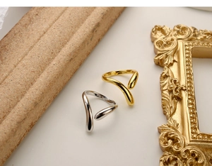 Dettaglio del marchio S925 su anelli aperti minimalisti in oro e argento sterling