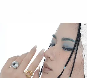 Artistic contrast of silver liquid metal ring and gold multi-layer wrap band on model finger