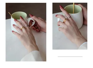 Detail of s925 silver chain link and twisted rope rings on fingers in a cafe setting