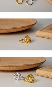 Macro shot of minimalist intertwined gold and silver rings on elegant stone bases