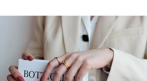 Chic silver rope ring and golden chunky chain link ring worn together on model finger