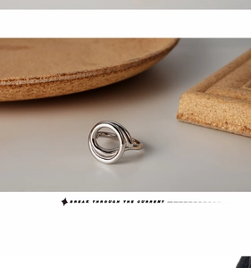 Detailed view of silver-toned hollow geometric ring with polished spiral lines design