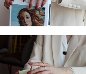 Detail of gold twisted ring and silver Cuban chain link ring worn on model fingers