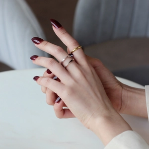 Elegant gold round ring and silver double-layered Mobius band on a female model hand