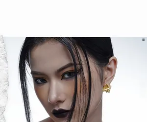 Close-up of golden lava texture earrings with irregular creased metal finish on a model