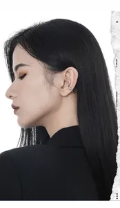 Dettaglio di un ear cuff in argento minimalista con linee curve irregolari sul profilo viso