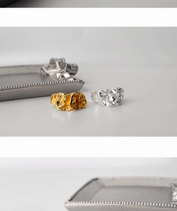 Macro detail of silver and gold rings with artistic wrinkled foil texture and metallic finish