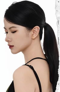 Close-up of minimalist gold hoop earring and silver cuff on model's ear in chic style
