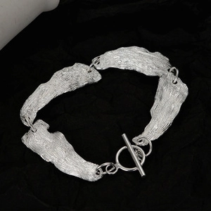 Vista detallada de la pulsera de plata S925 con textura irregular y cierre de palanca OT