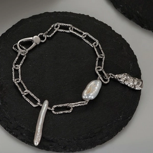 Detalle de pulsera en plata S925 con perlas barrocas y colgante de criatura mítica
