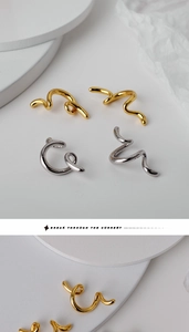 Macro di orecchini a clip in argento sterling S925 con curve irregolari in finitura oro e argento