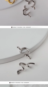 Dettaglio macro di orecchini S925 in argento sterling con linee ondulate moderne