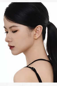 Close-up of minimalist geometric s925 silver ear cuff and oval earring on model ear