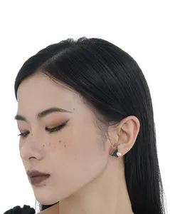 Close-up of minimalist triangle stud earring with marble texture and round pearl inlay