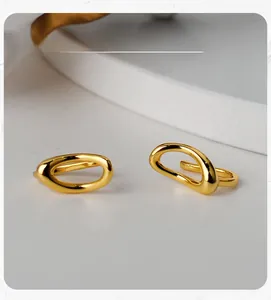 Macro shot of minimalist gold S925 silver irregular geometric ear clip on white display