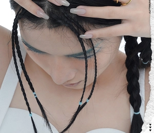Detail shot of minimalist gold rings paired with light blue hair ties on model