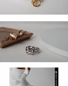 Close-up of multi-layer knot rings in gold and silver finish with high-polish texture