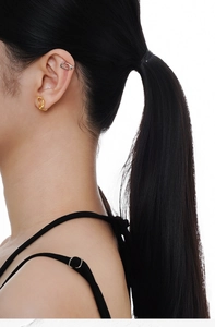 Close-up of minimalist gold twisted stud and silver geometric ear cuff on model