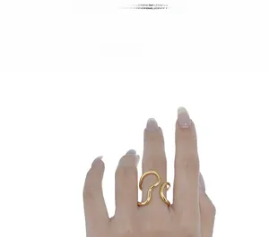 Detailed view of an 18K gold plated irregular wave ring on a female model's index finger