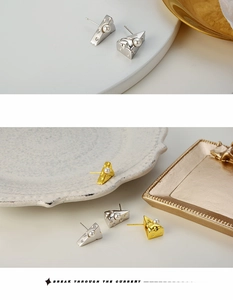 Detail of creative cheese shaped stud earrings with white pearls in gold and silver finish