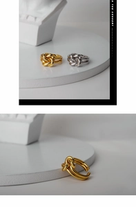 Macro shot of layered knot design rings in gold and silver finish with adjustable band