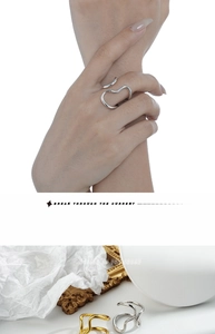 Macro detail of irregular wave open rings in polished silver and gold metal finishes