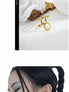 Close-up of abstract golden wave pattern ring with an adjustable open design