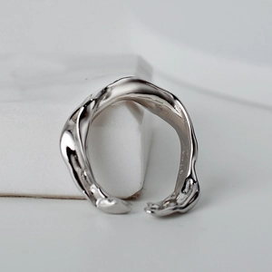 Bague ouverte irrégulière en argent sterling S925 au design fluide sur socle en marbre