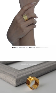 Macro detail of gold adjustable ring with unique origami texture and metallic cylinder