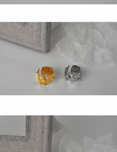 Detailed view of silver and gold wide rings with unique wrinkled foil texture finish