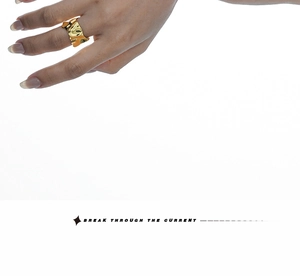 Detailed view of the wide golden ring with irregular crumpled lava texture on fingers